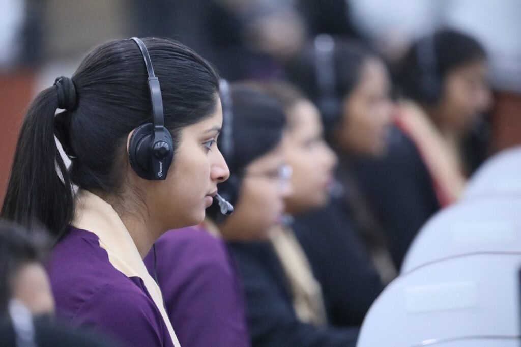 Filipino call center agents working at their desks, wearing headsets and assisting customers.