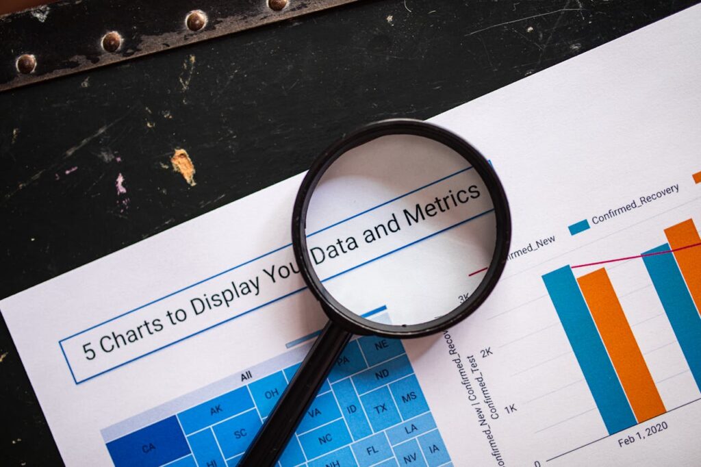 A magnifying glass placed over a printed data analysis report with bar charts and metrics, representing business insights.