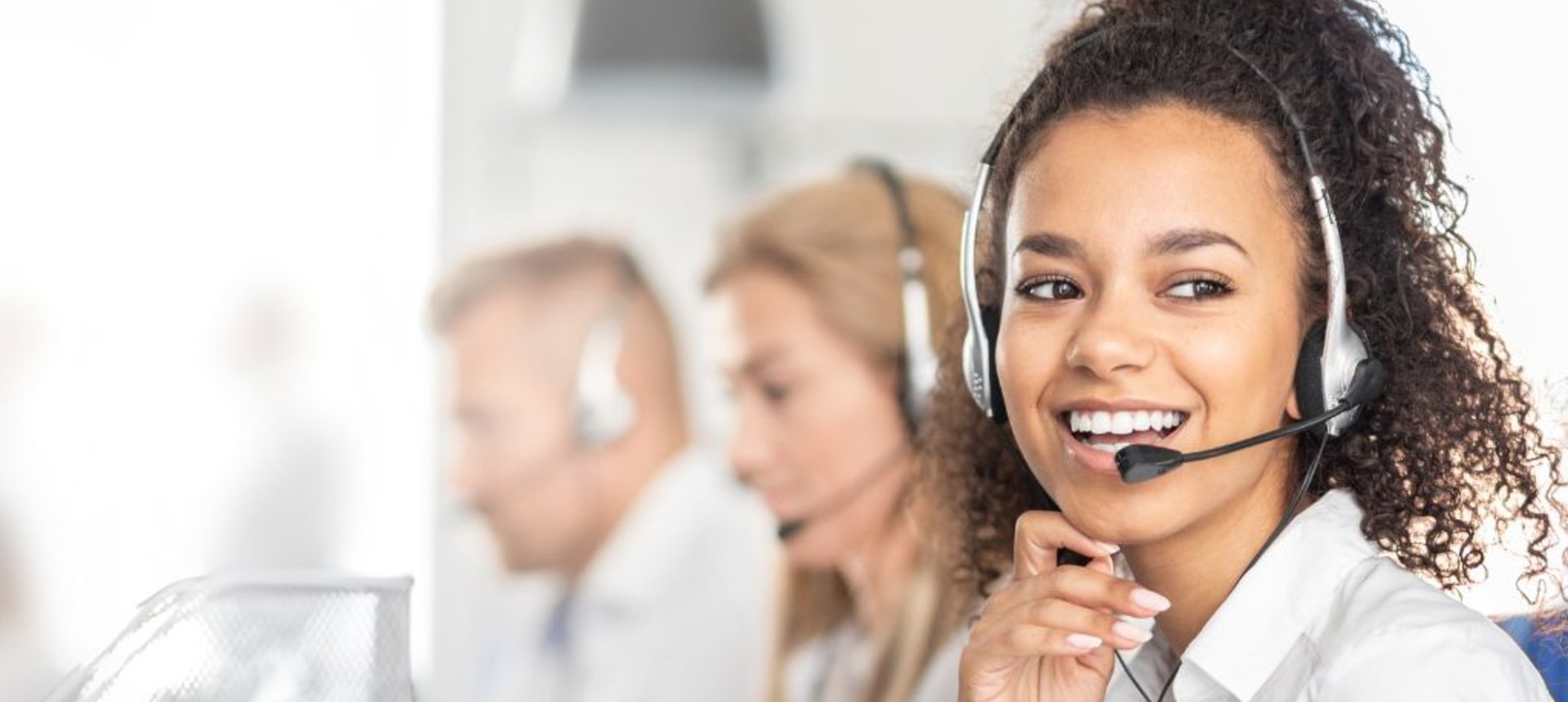 Smiling content moderator with a headset in a trust and safety operations team, representing content moderation outsourcing in the Philippines