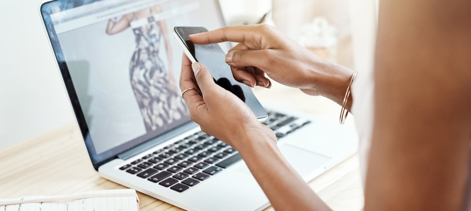Shopper on a smartphone in front of a fashion product page, an order a dropshipping team has to fulfil