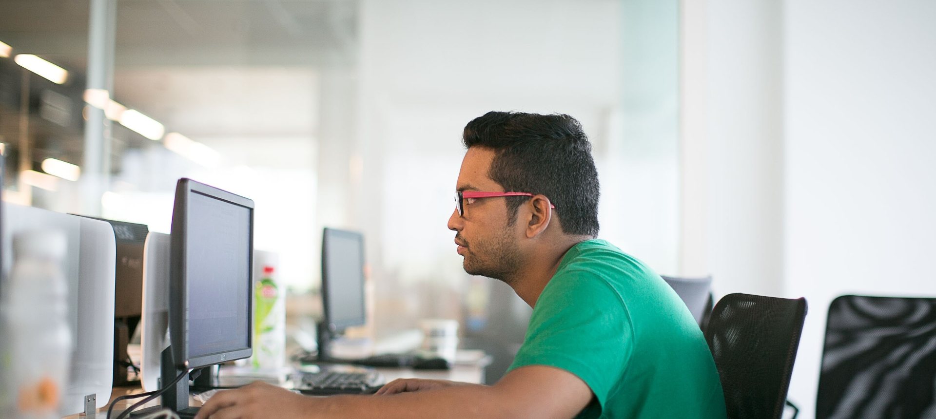 EdTech support specialist working at a computer in a bright open-plan office, representing EdTech support outsourcing in the Philippines