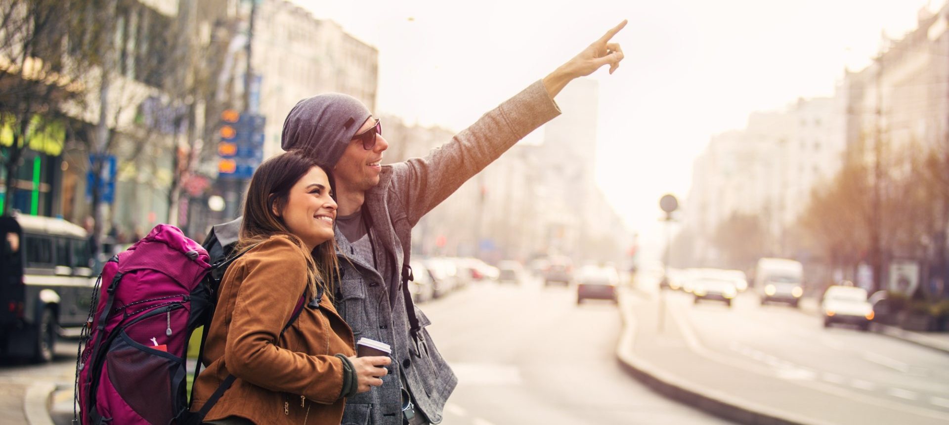 Travelers with a backpack pointing out a city sight, the kind of request a travel concierge arranges