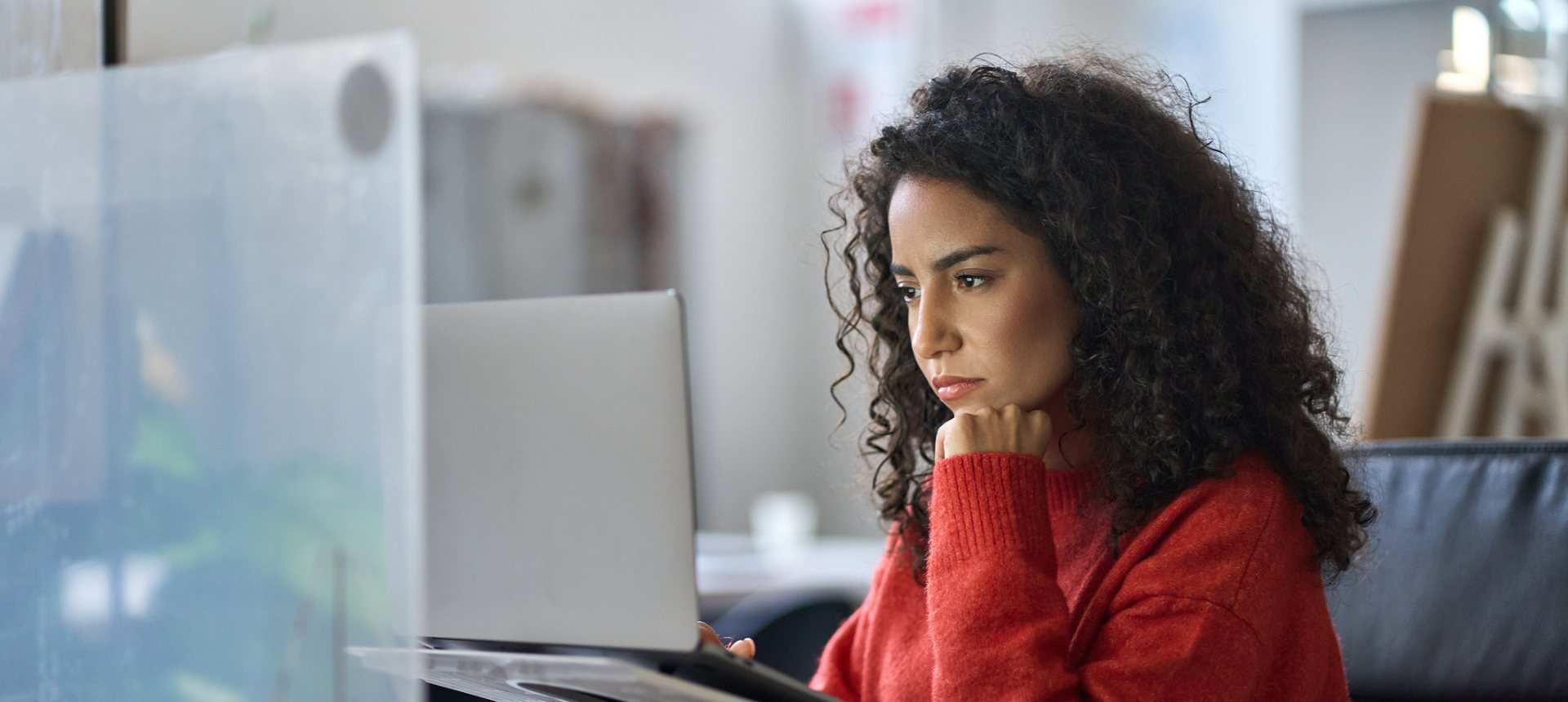 Evaluator in a red sweater studying an image-and-text model output on her screen