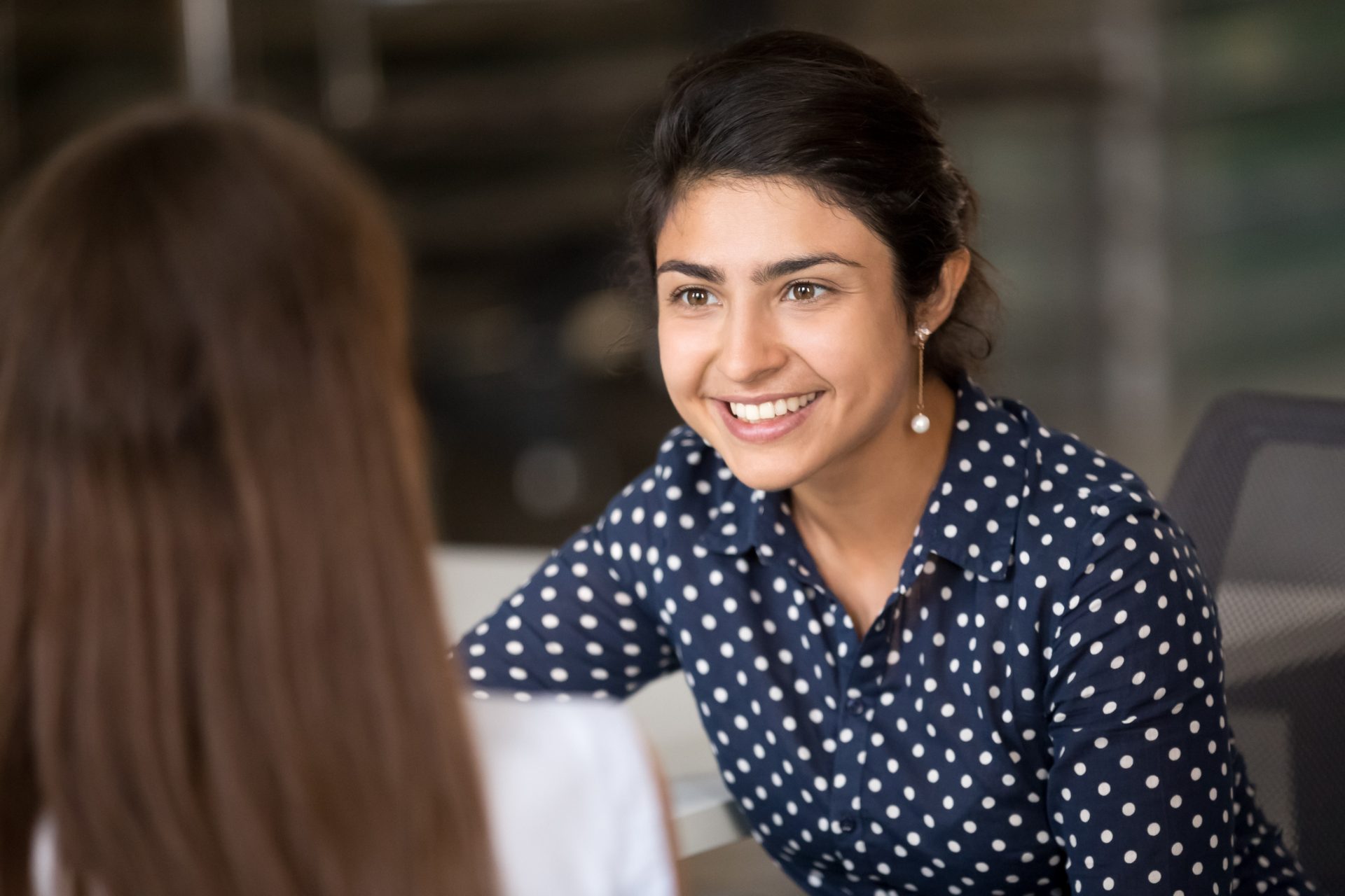 Smiling customer experience professional in conversation with a colleague, representing the Philippines vs India outsourcing decision