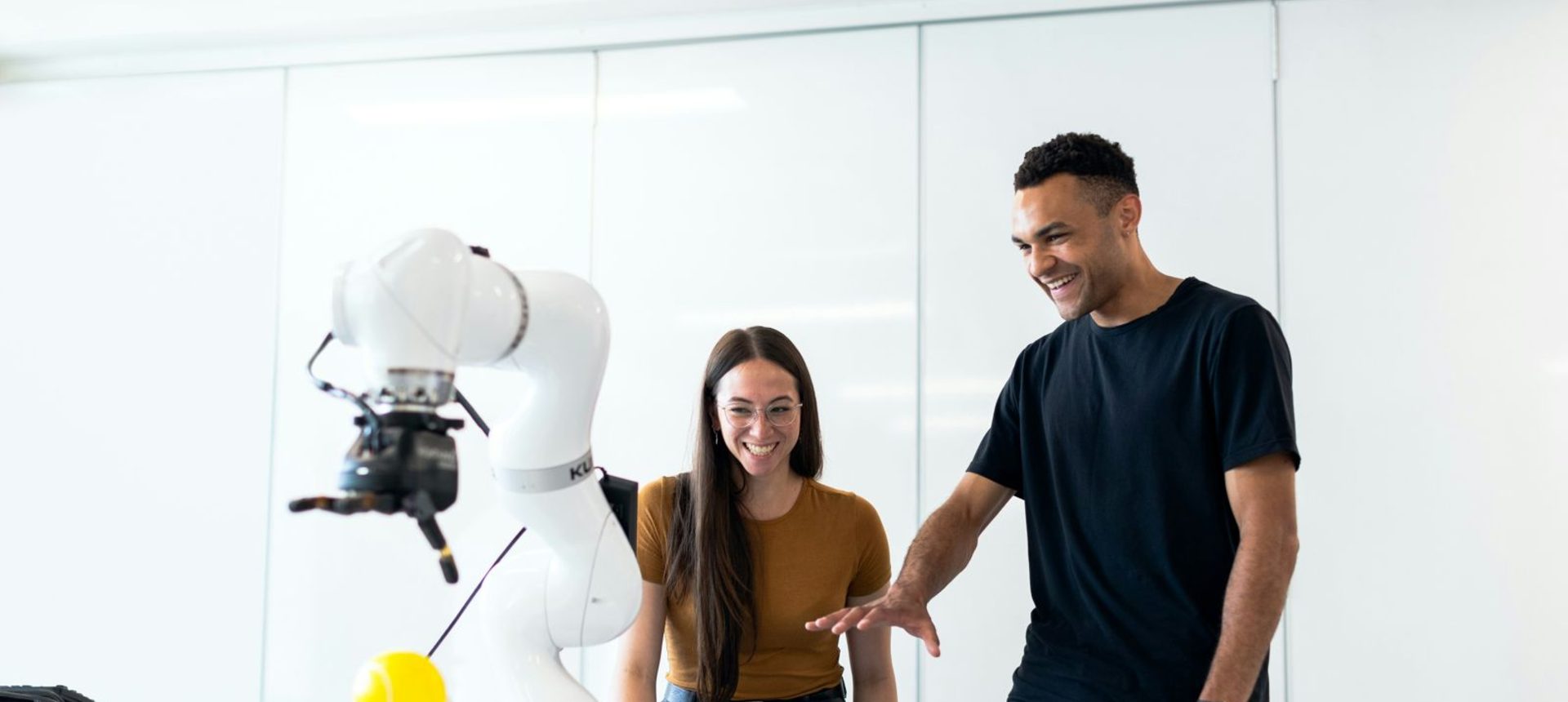 Engineers watching a robot arm run a task, the kind of behavior an RL environment scores
