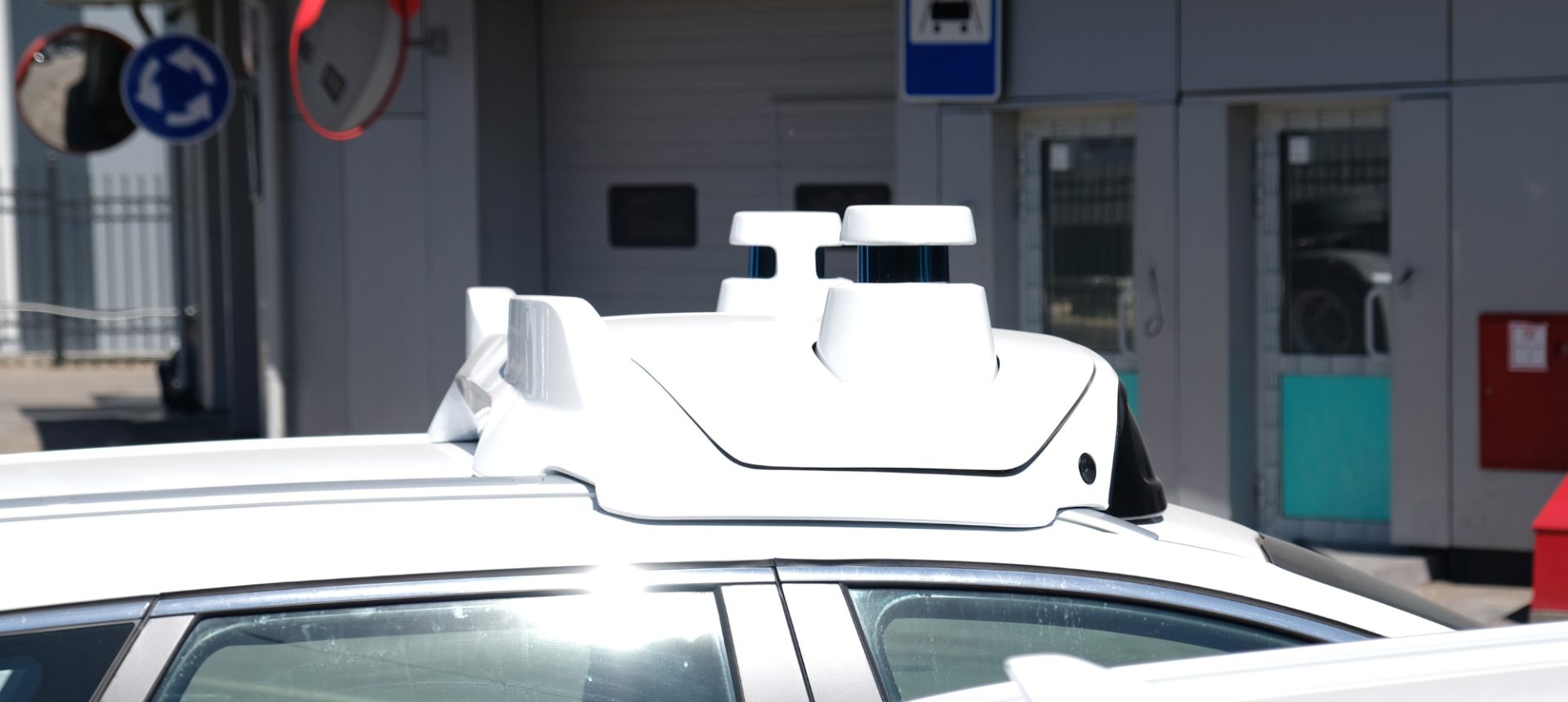 Roof-mounted LiDAR and camera pod on a white test vehicle, the rig behind sensor and LiDAR data collection