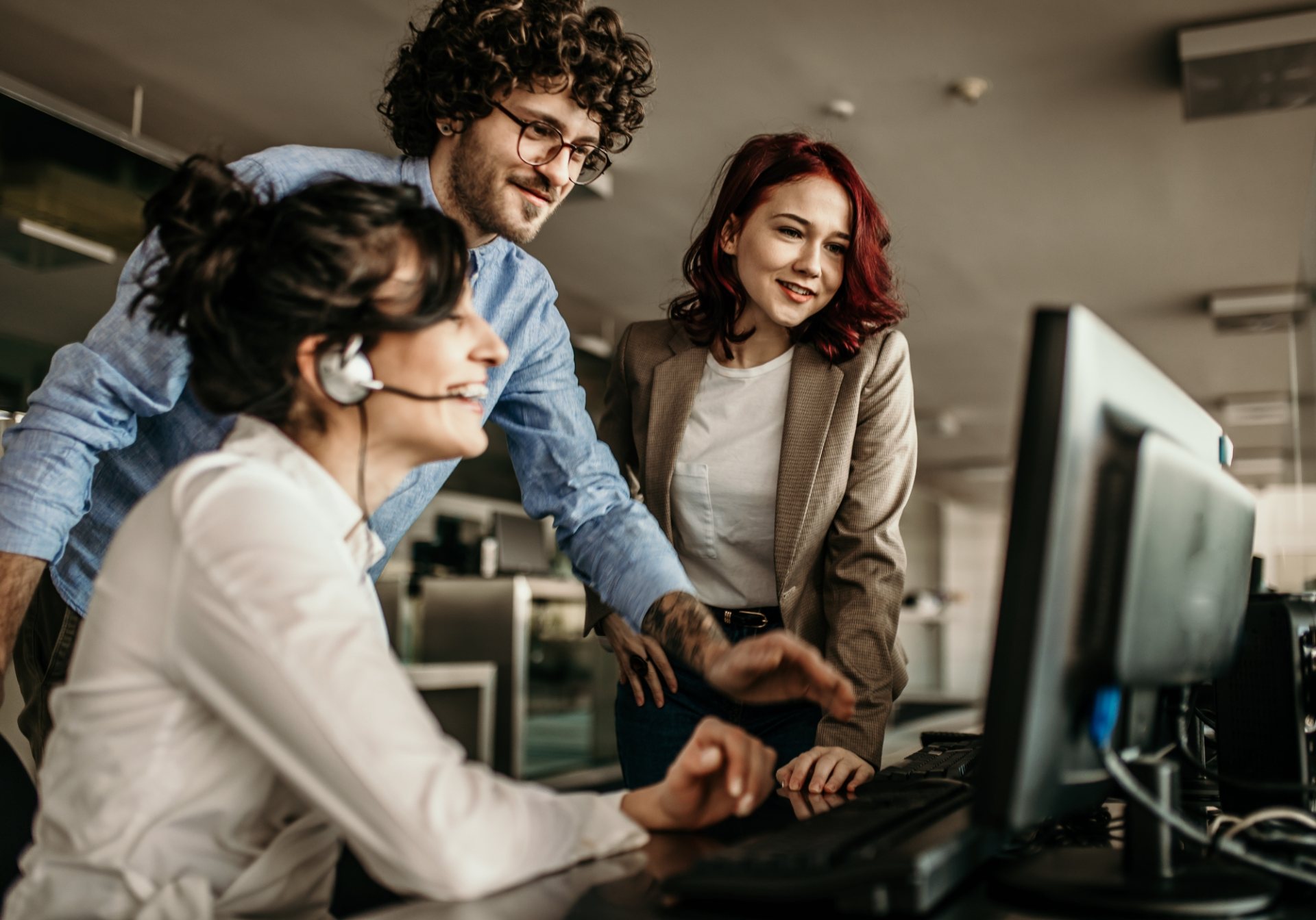 Support agent with a headset and two colleagues reviewing a Seller Central case on screen