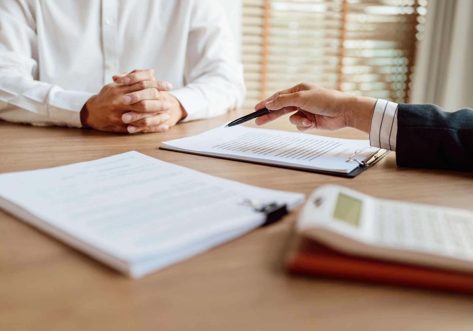 Agent pointing a pen at a contract on a clipboard, checking coverage before a certificate of insurance is issued
