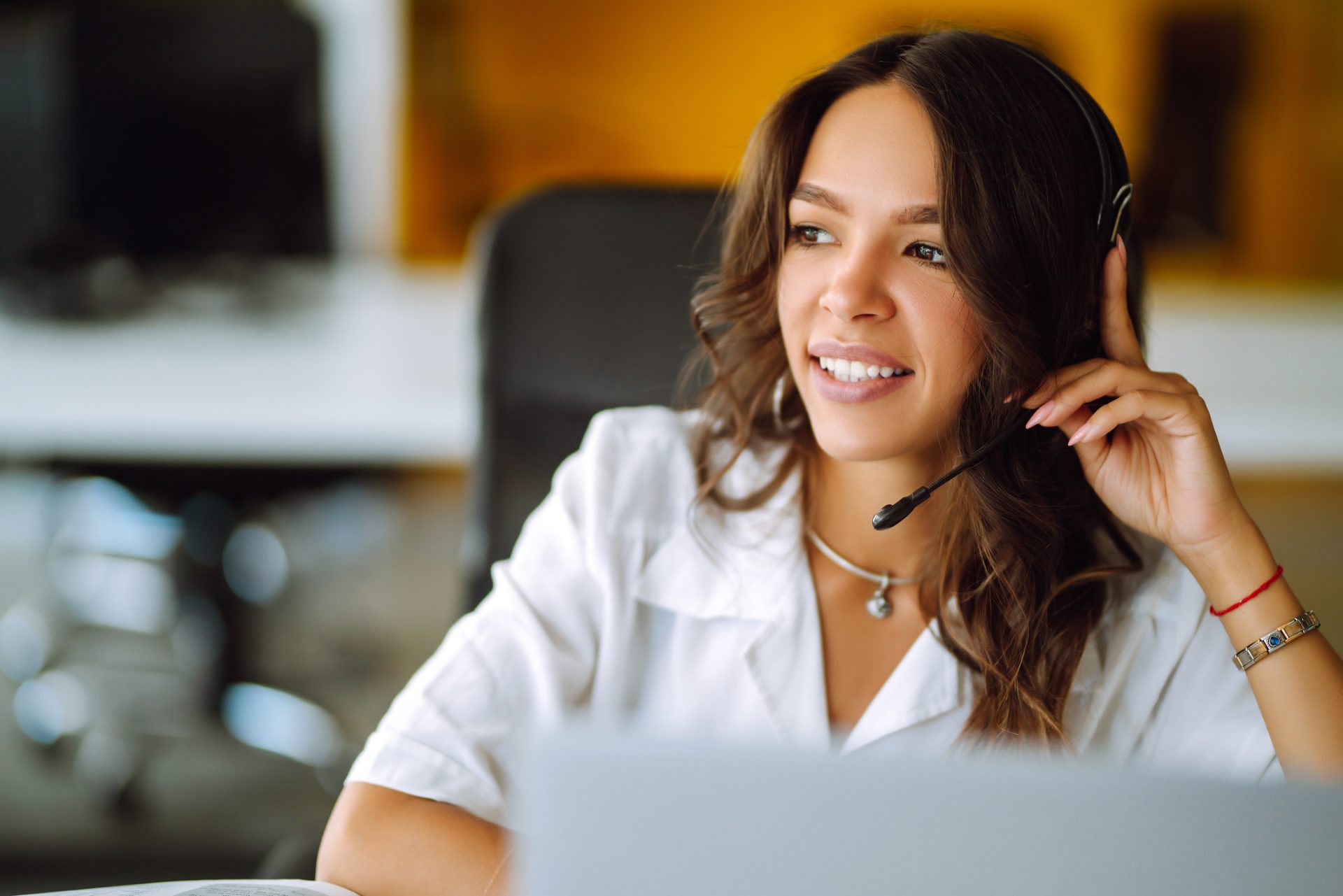Customer retention specialist with headset smiling during a save call, representing customer retention outsourcing to the Philippines