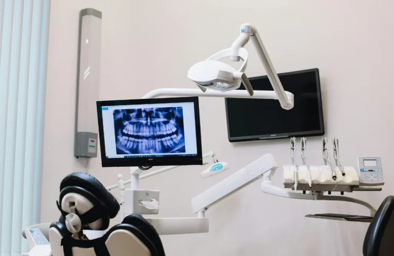 Dental treatment room with a panoramic X-ray on screen, for a post on dental insurance verification checklist