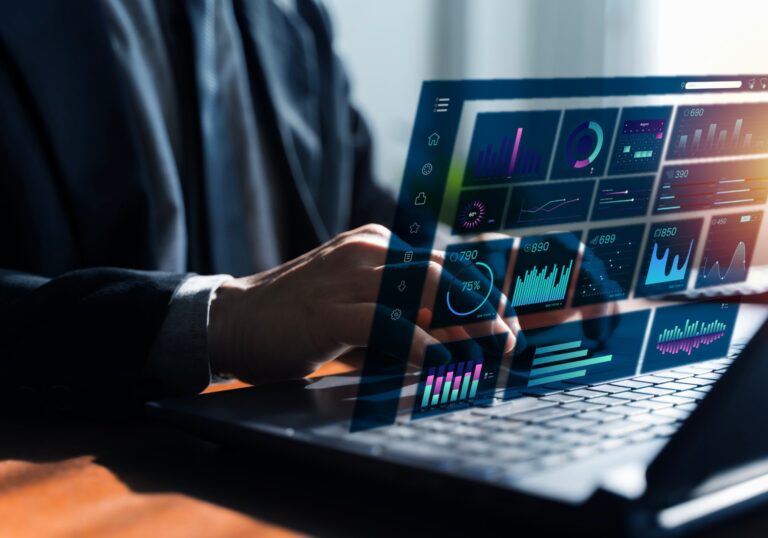 Hands typing on a laptop with data dashboards projected above the keyboard, for a post on table annotation guidelines