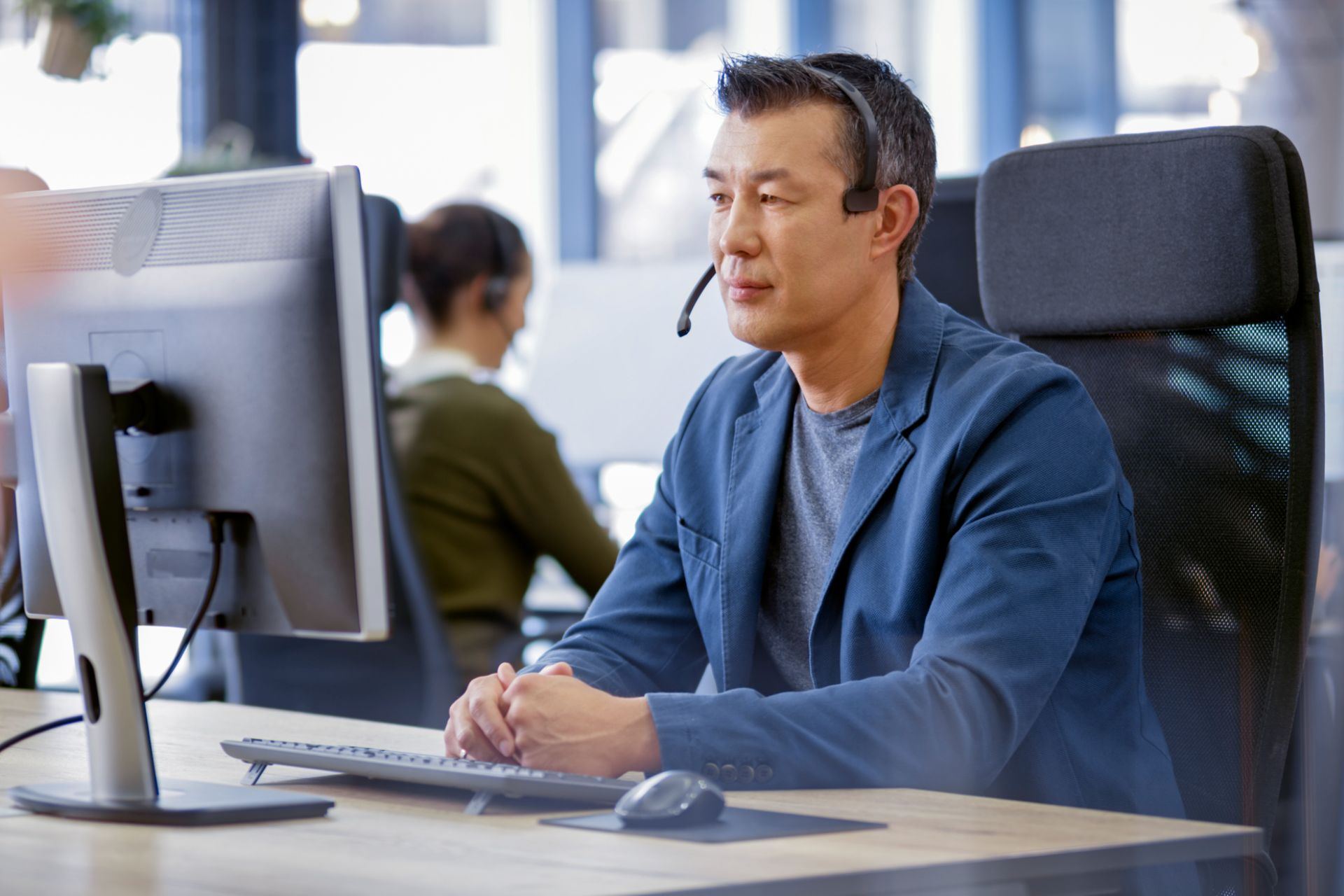Contact center agent in a headset working at a secured workstation in a modern Philippine delivery center