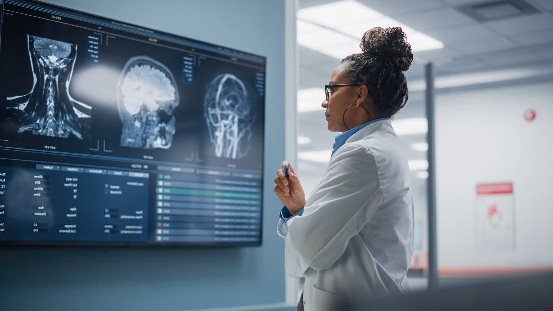 Physician reviewing MRI brain scans on a clinical display, representing healthtech support delivered by Philippine BPO teams