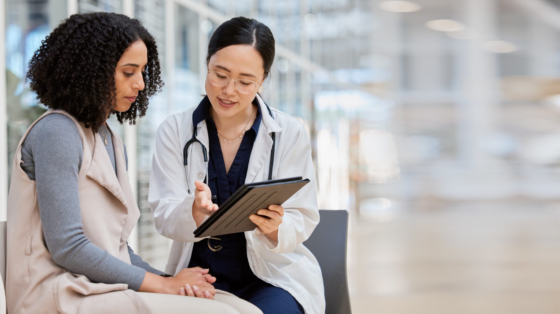 Doctor reviewing a patient record on a tablet with a colleague, representing healthcare and life sciences outsourcing to the Philippines