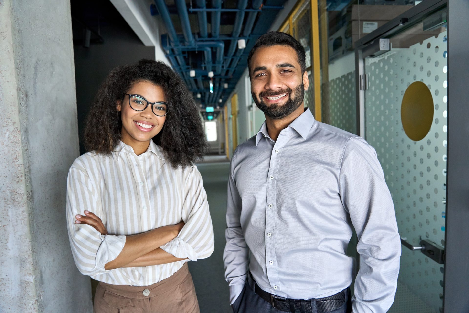 Two professional services consultants standing in a modern office, representing professional services outsourcing to the Philippines