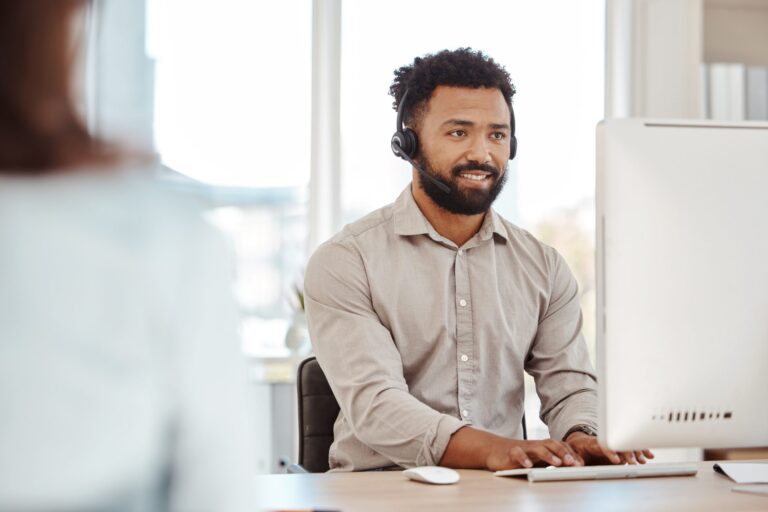 Technical support specialist with a headset at his desk, for a post on support led growth SaaS