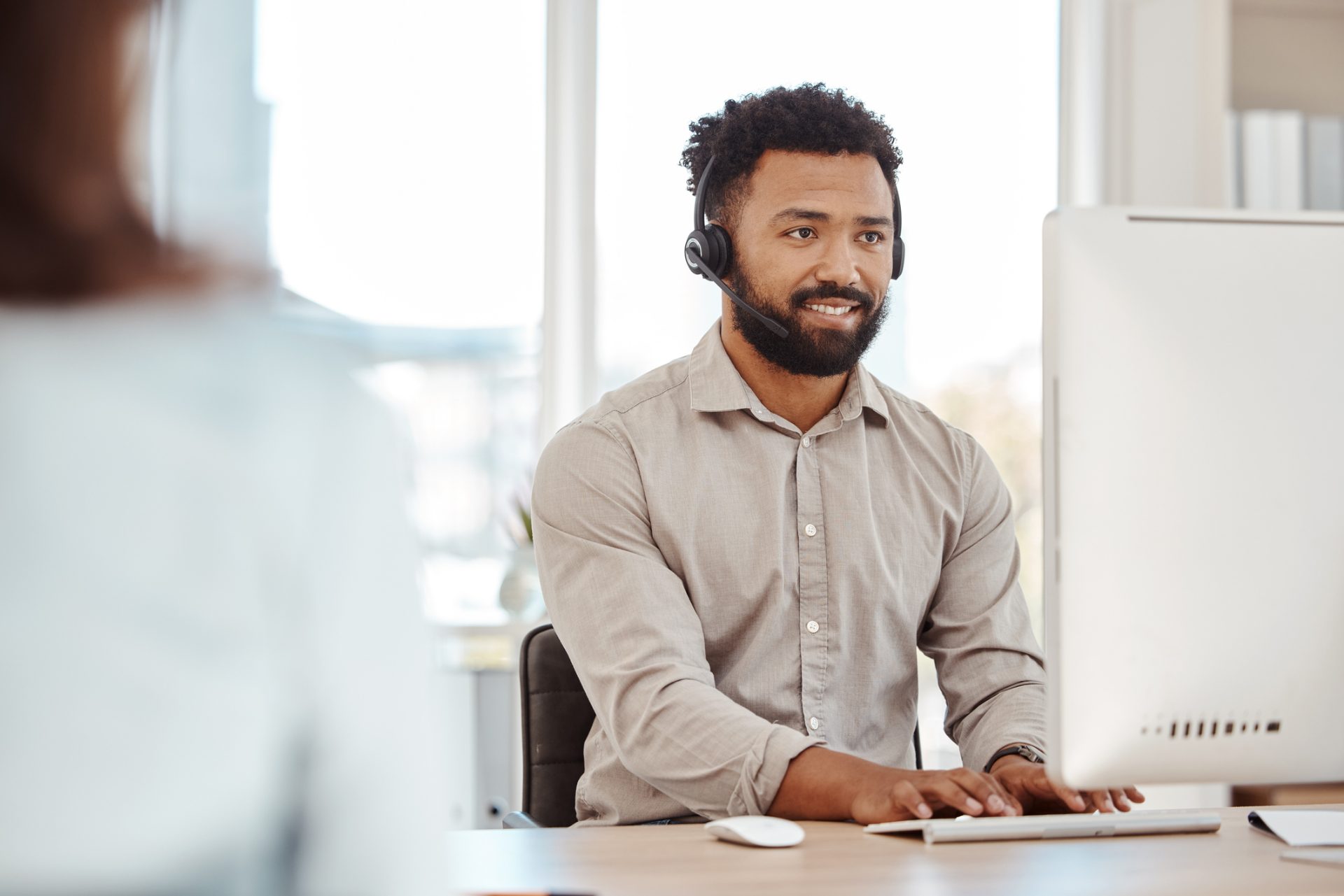 SaaS technical support specialist with headset working at his desk, representing technology and SaaS outsourcing to the Philippines
