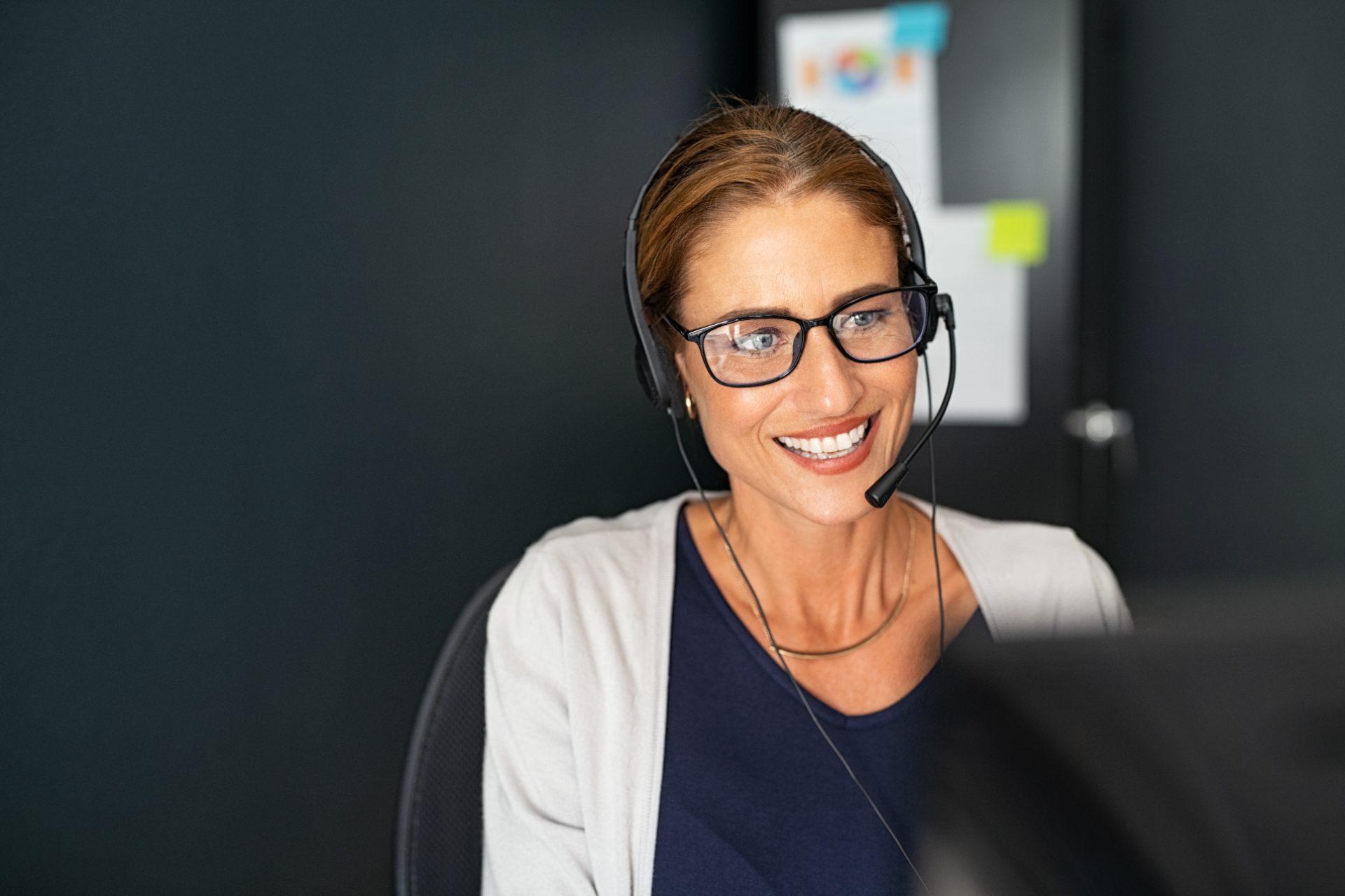 Contact center agent with headset and glasses on a customer call, representing voice, CX and contact center outsourcing to the Philippines