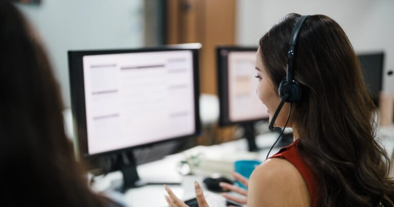 Insurance specialist reviewing claims history on two monitors, for a post on how to read a loss run report