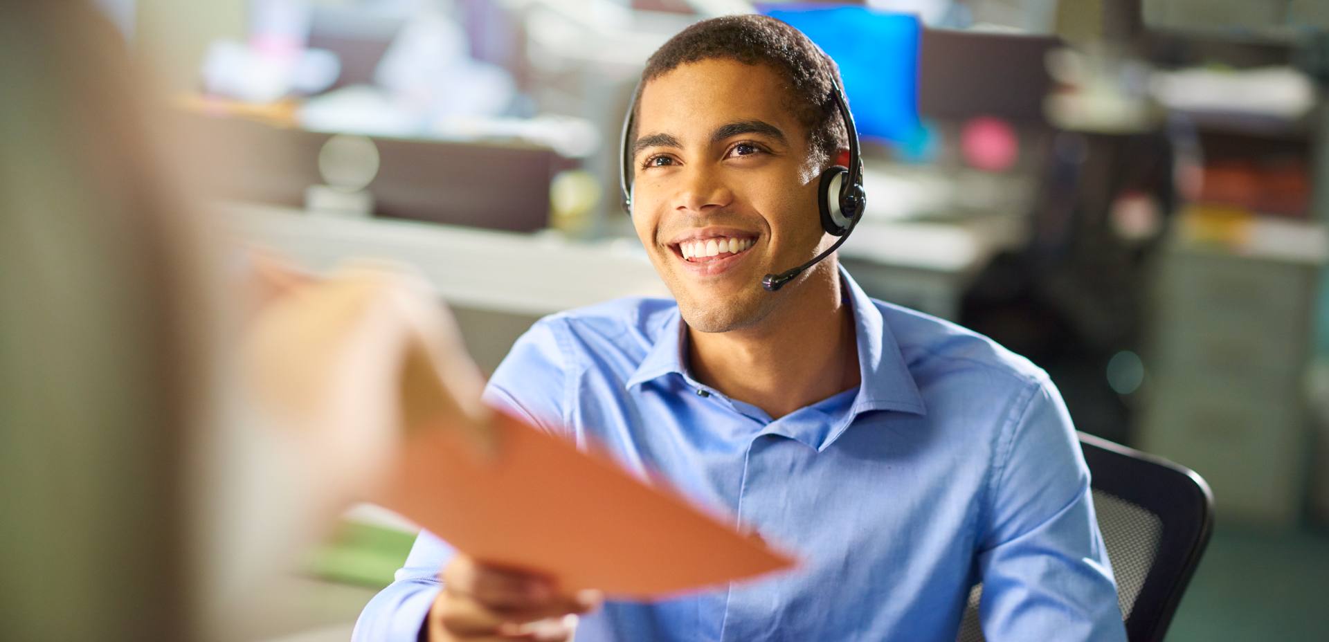 Medical billing specialist with headset receiving patient billing documents at a Philippine outsourcing provider