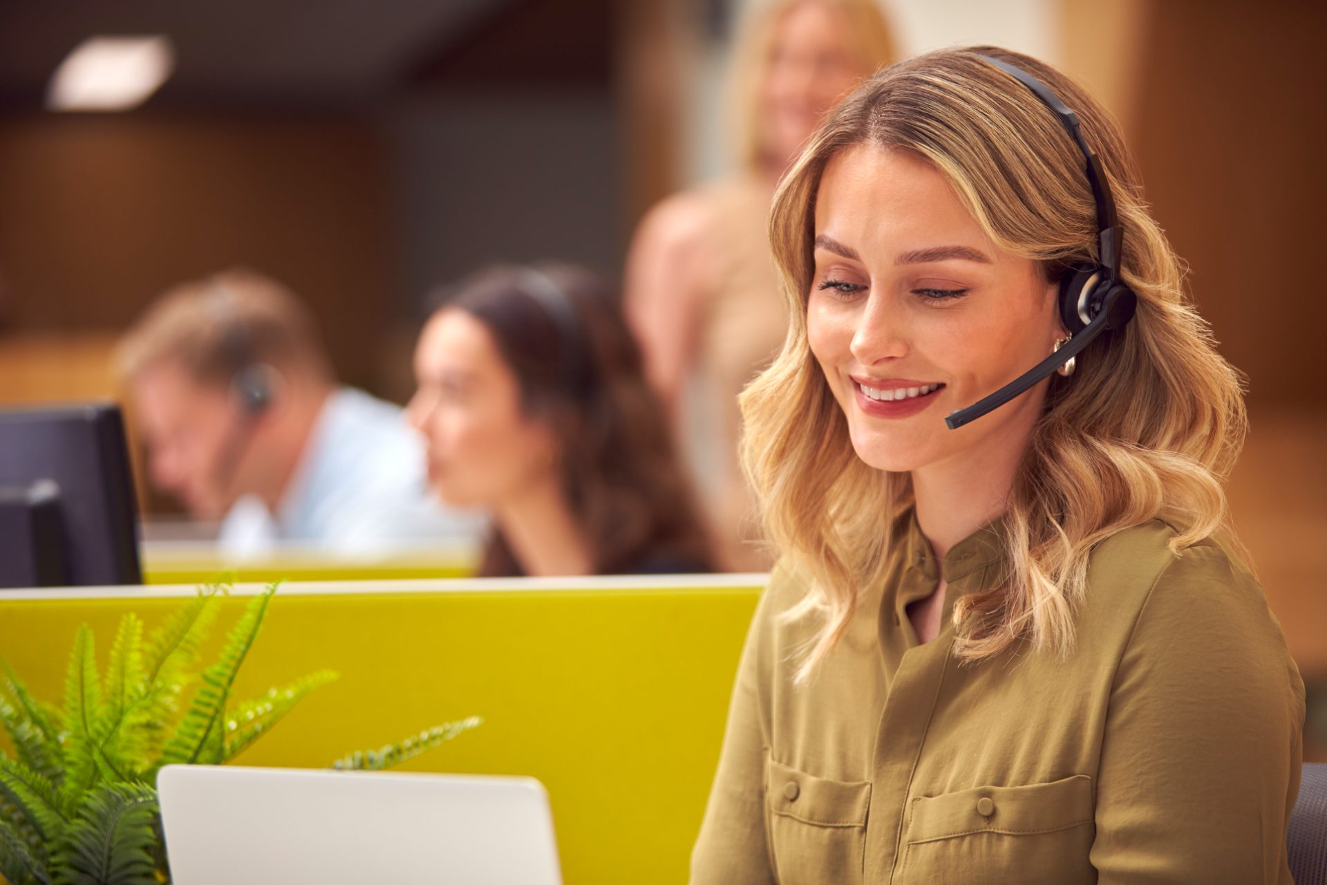 Smiling contact center agent with headset handling customer conversations on a multichannel contact center floor, representing omnichannel contact center outsourcing to the Philippines