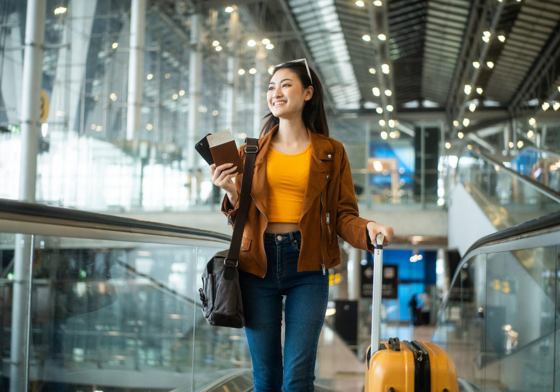 Traveler with a passport, boarding pass and suitcase on an airport escalator, a trip an OTA team may rebook