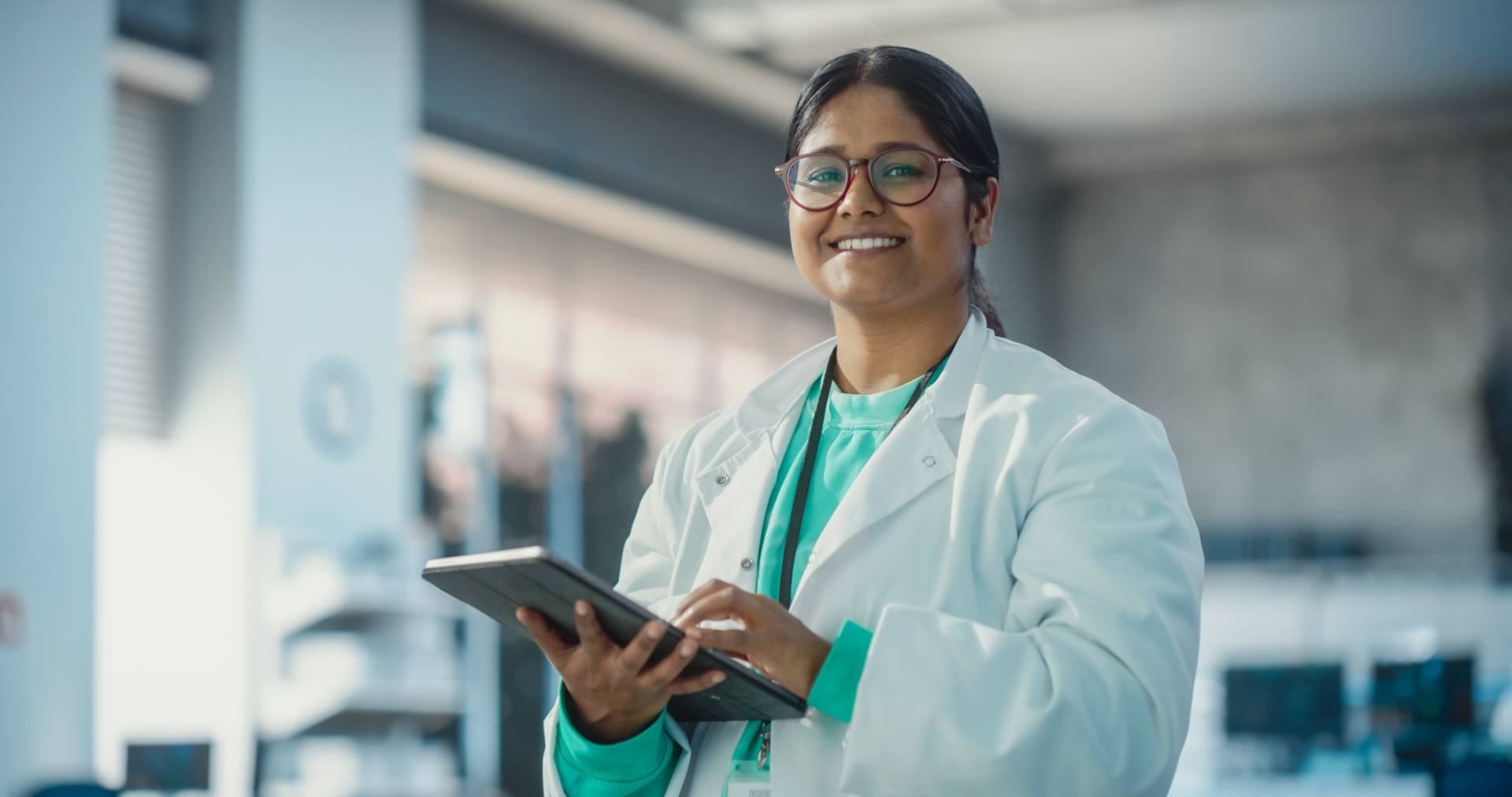 Pharmaceutical scientist checking results on a tablet in a lab