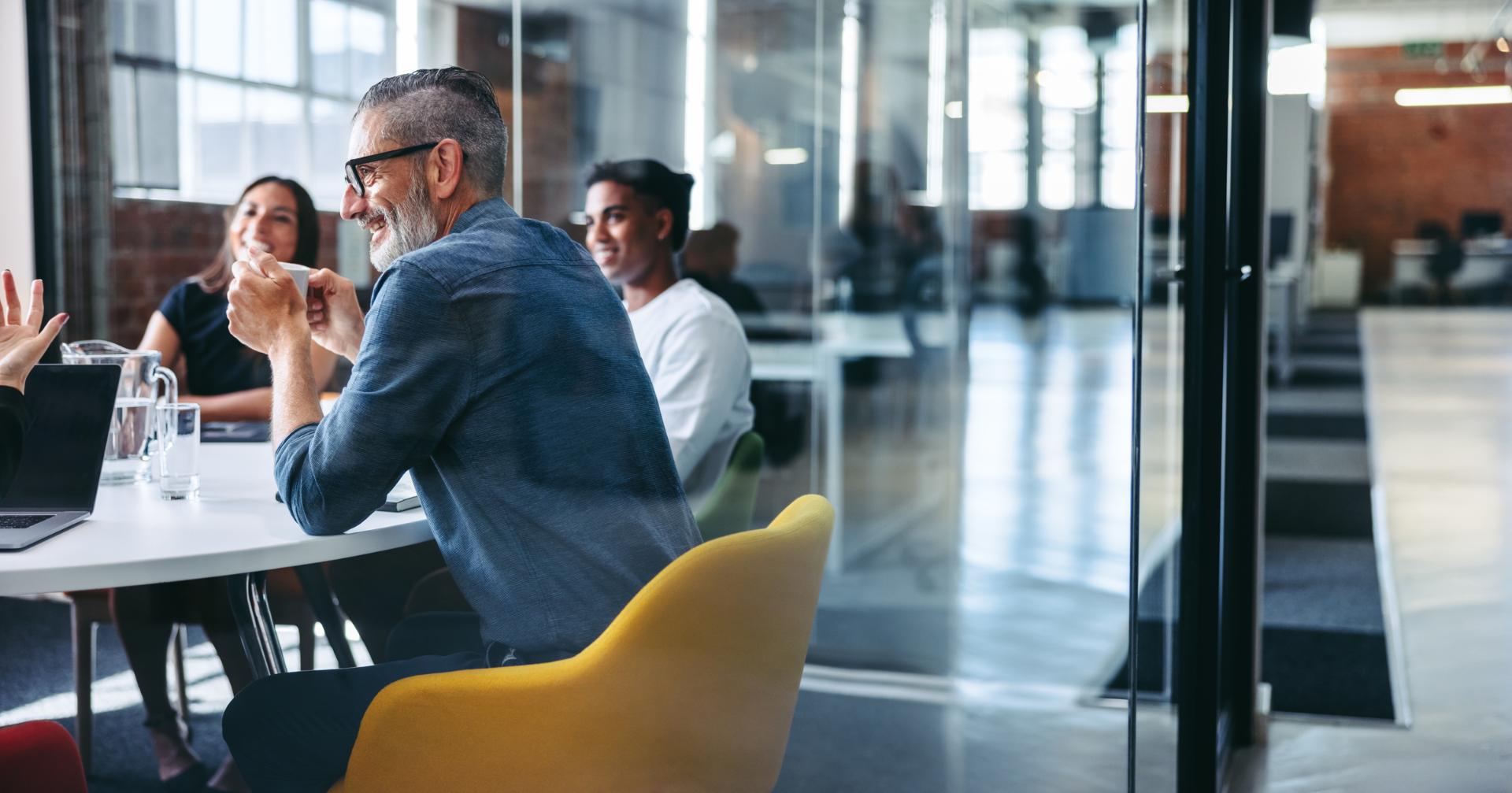 Property managers and agents meeting around a table in a glass-walled real estate office