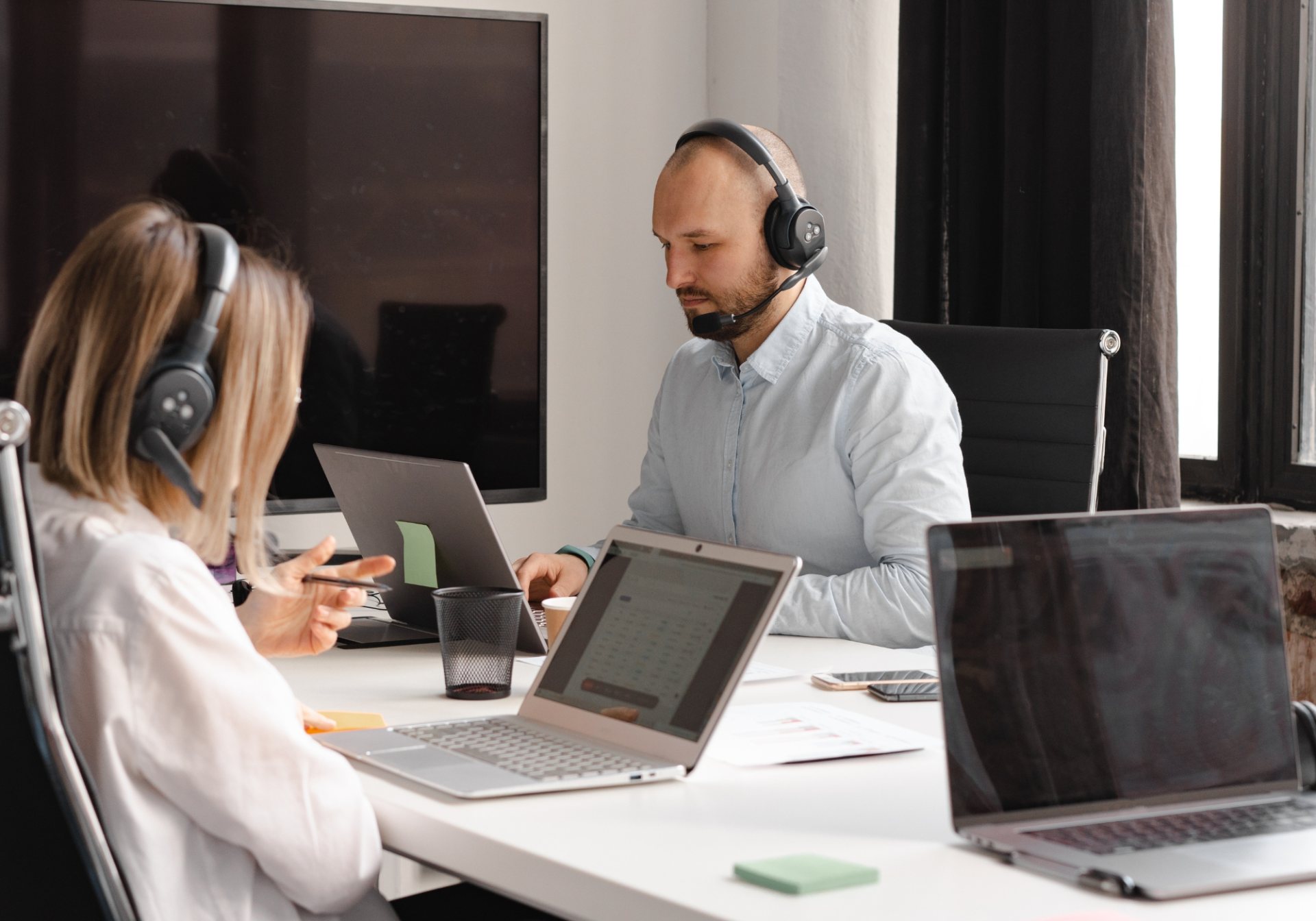Two specialists with headsets rating model responses at their laptops for a reward model