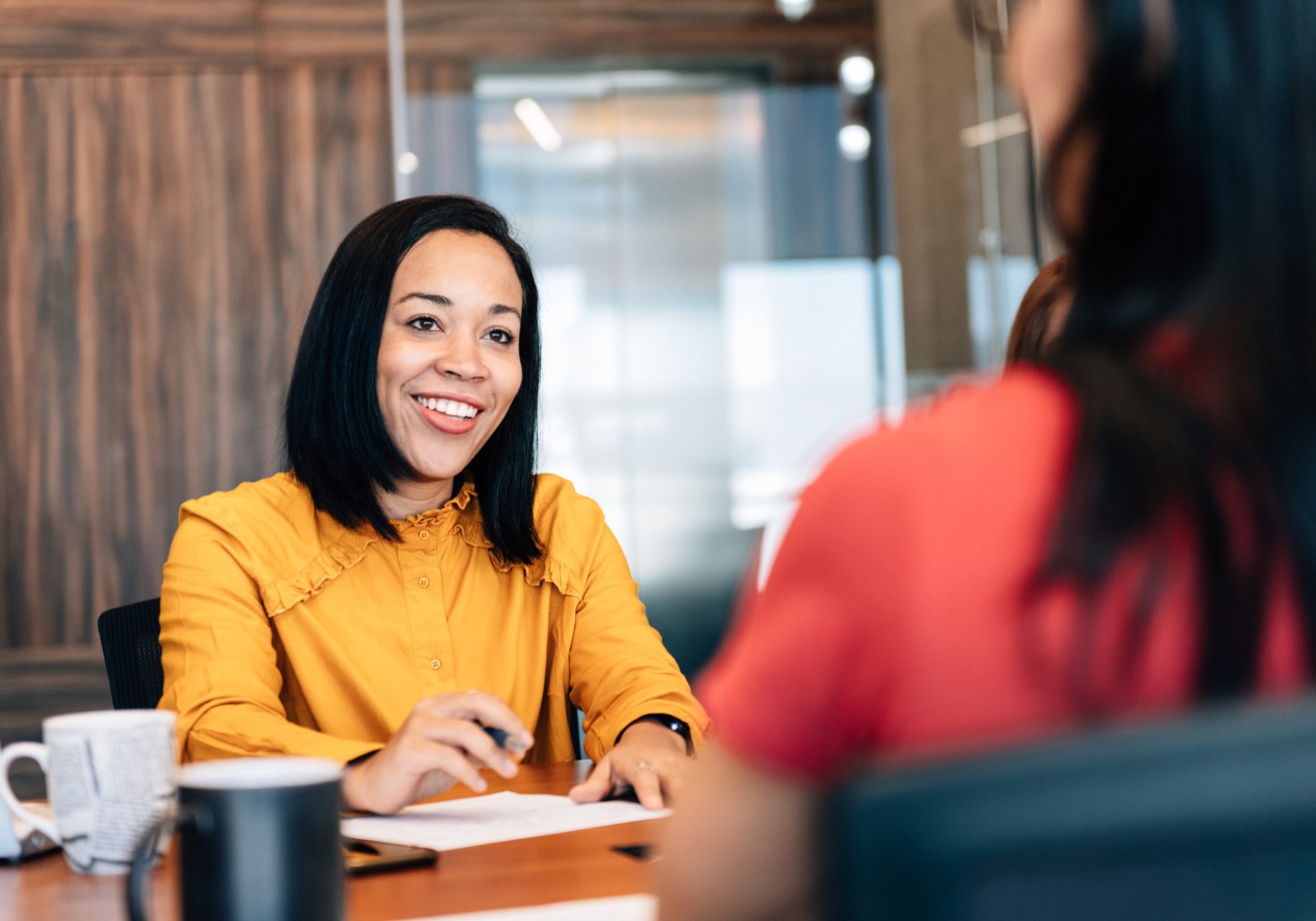 Advisor smiling across a meeting table with a client, the human conversation behind robo-advice