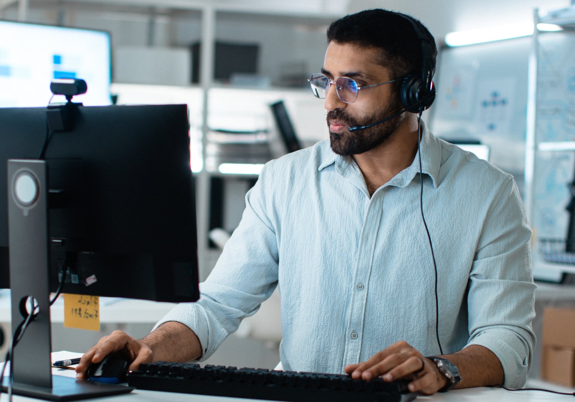 Annotation specialist with a headset working at a desktop monitor, for a post on LiDAR annotation quality checks