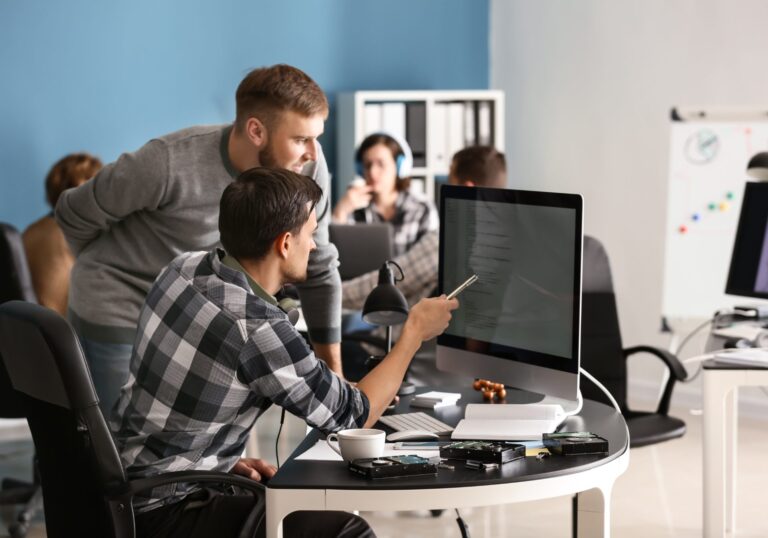 Two security analysts reviewing an alert on a monitor in an operations office, for a post on SOC alert triage playbook