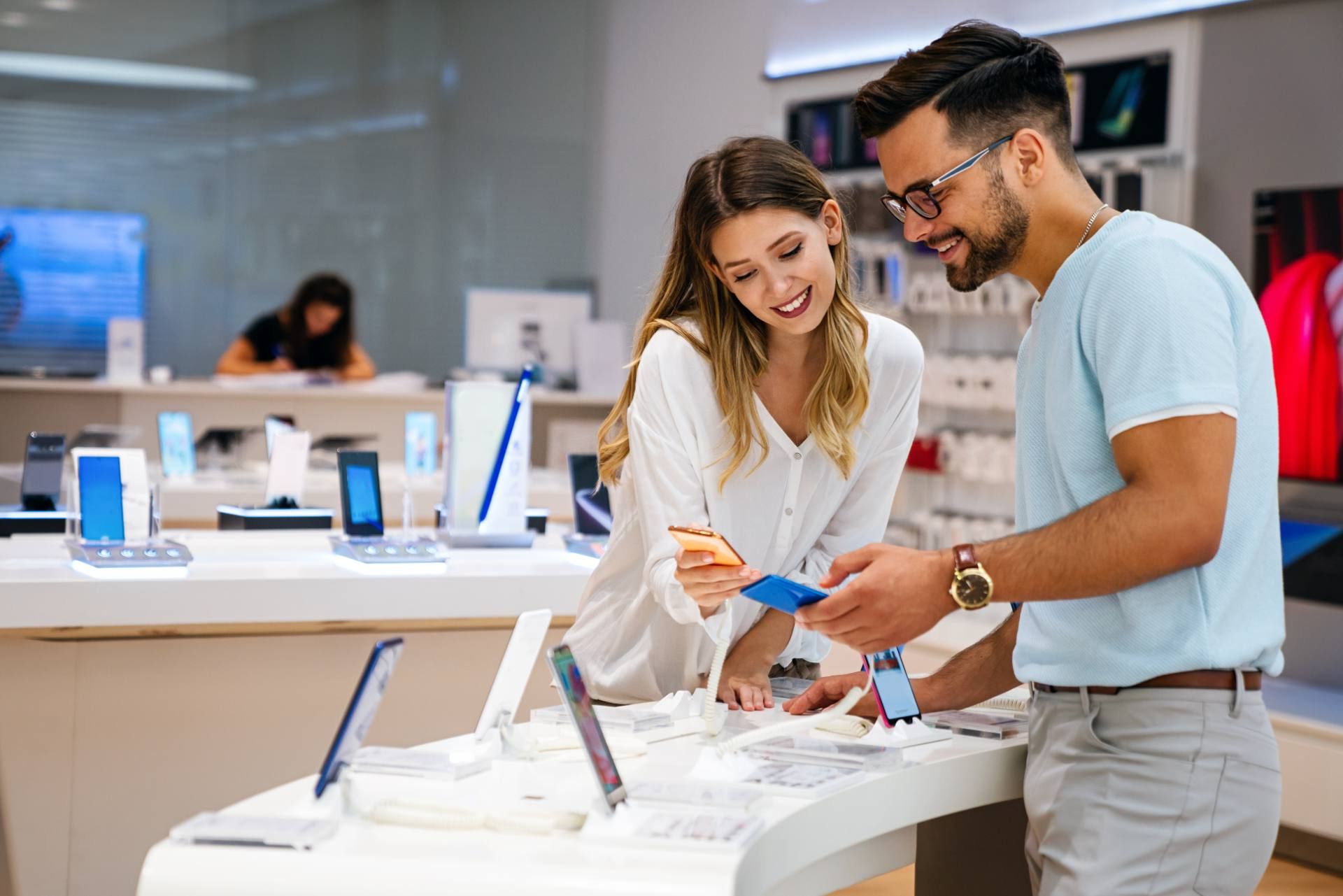 Customers comparing smartphones in a telecom store before choosing a plan