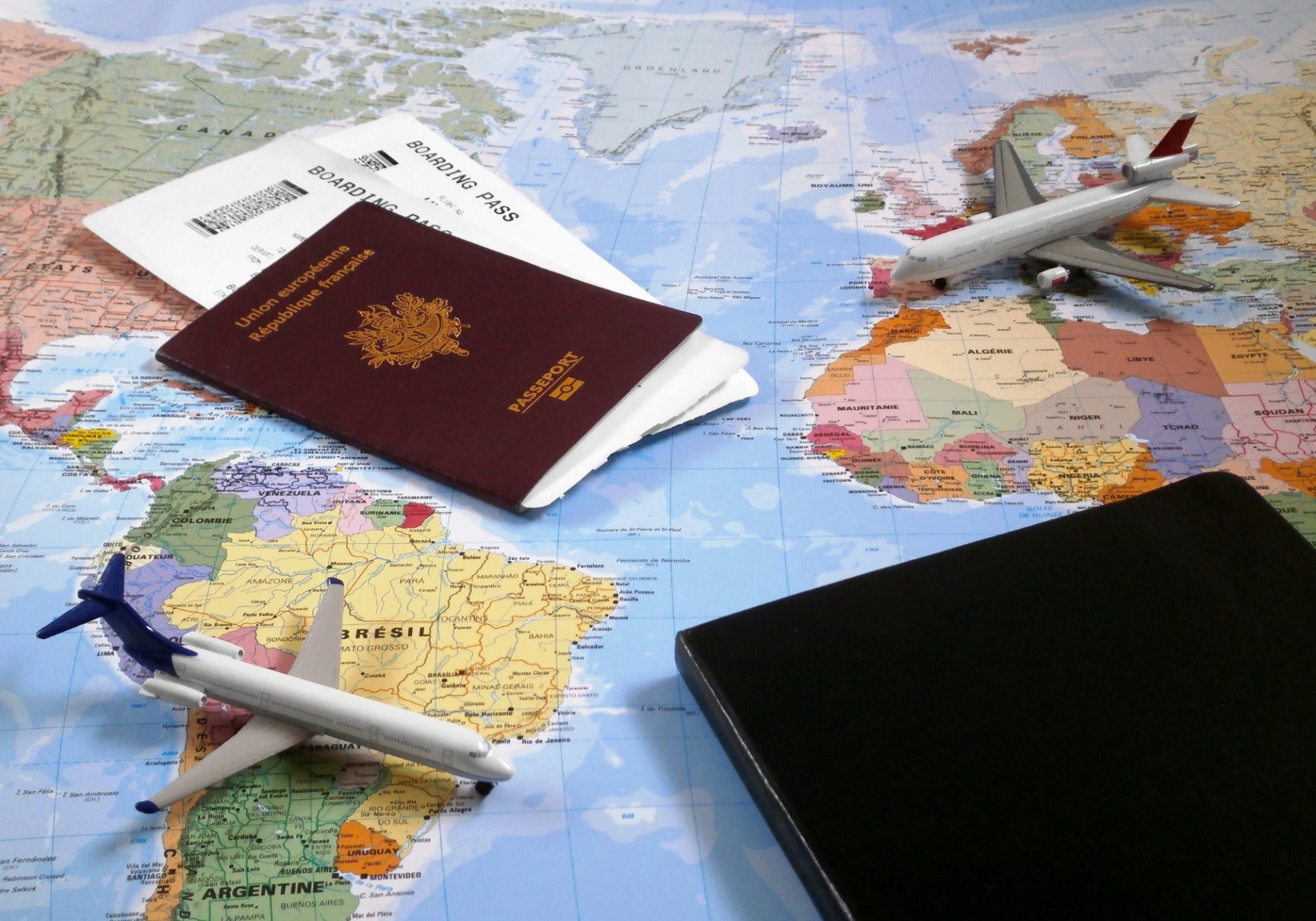 Passport, boarding passes and model planes on a world map, planning a tour operator itinerary