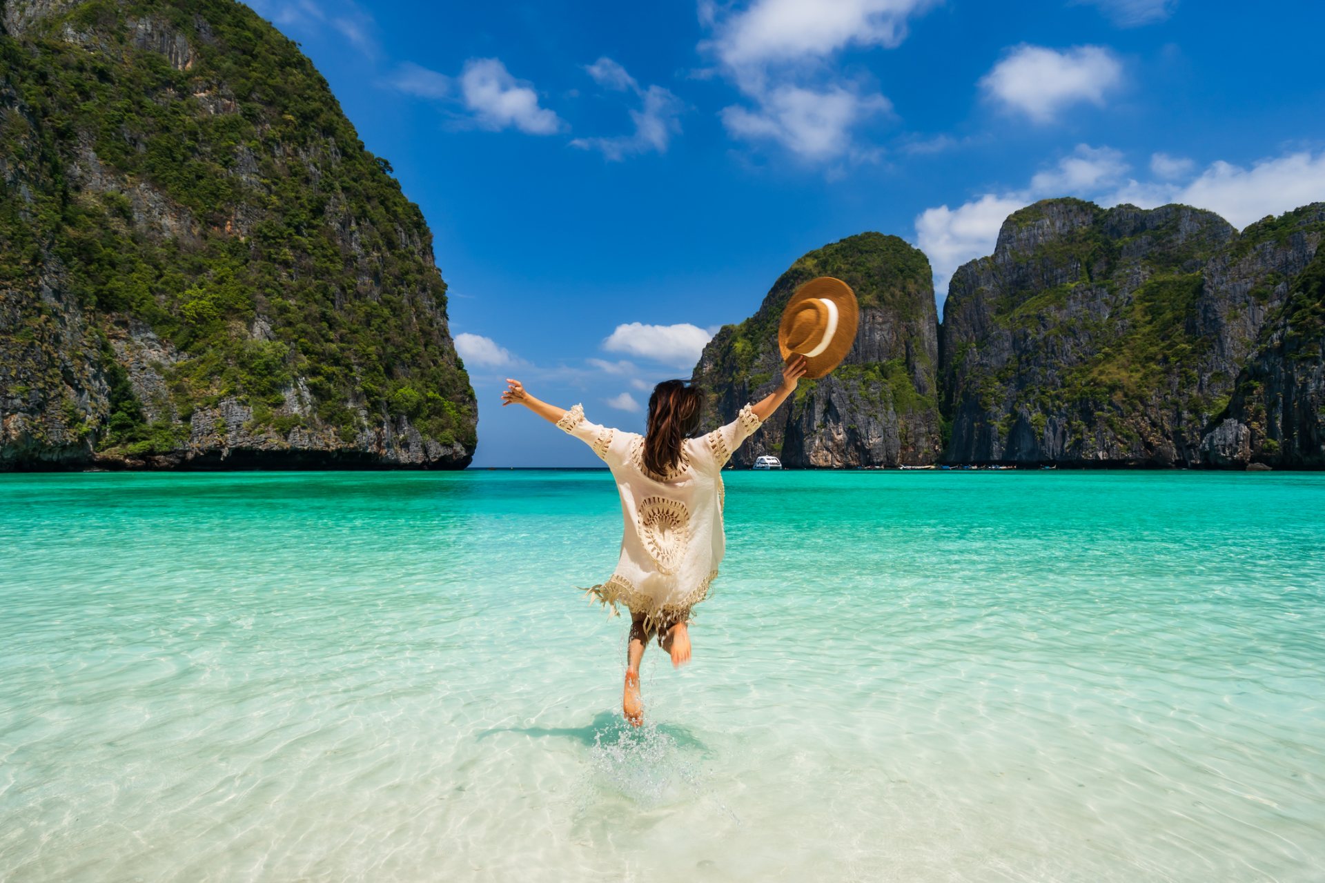 Guest running into clear turquoise water at a tropical beach, representing vacation rental guest support outsourcing to the Philippines